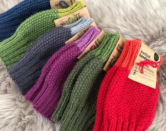 May include: A set of 8 knitted hats in various colors, including red, green, purple, blue, and gray. The hats are made of 100% British wool and are hand-knitted in North London. Each hat has a tag that says "Knitted Handwear" and "100% British Wool Hand-Knitted in North London."