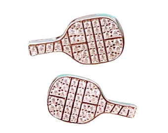 May include: A pair of silver earrings shaped like a paddle, each earring is covered in small, clear rhinestones.