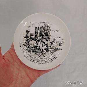 Könnte beinhalten: Ein weißer Keramikteller mit einer Schwarz-Weiß-Illustration einer Pferdekutsche. Der Teller hat Text am Rand, einschließlich des Satzes "Want of care does us more damage than want of knowledge."