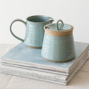 Puede incluir: Un letrero de madera rústico con el texto "Welcome to our home" en un estilo manuscrito. El letrero presenta un acabado envejecido y un diseño sencillo y acogedor, perfecto para un porche o entrada.