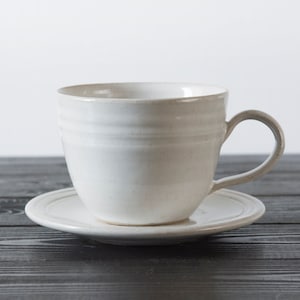 Keramik-Becher, weiße Teetasse und Untertasse