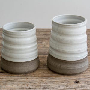 French country crock used as a floral centerpiece on a dining table.