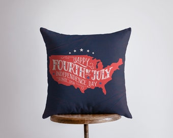 Op de afbeelding: Een donkerblauw kussen met een rode en witte afbeelding van de kaart van de Verenigde Staten. De afbeelding zegt "Happy Fourth of July Independence Day Since 1776".