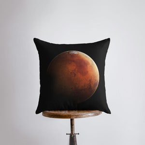Peut inclure: Un coussin noir avec une grande image détaillée de Mars, la planète rouge, au centre.