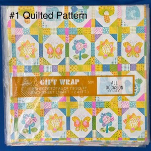 May include: A package of two sheets of gift wrap featuring a quilted pattern with butterflies, flowers, and birds. The wrap is yellow, blue, pink, and green. The package says "#1 Quilted Pattern" and "Gift Wrap 50c".