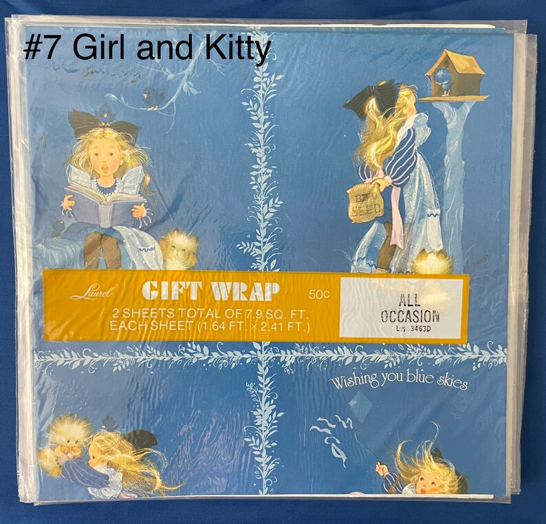 May include: A blue and white gift wrap with a girl and a kitten. The wrap features a girl reading a book, a girl looking at a bird in a birdhouse, and a girl with a kitten. The text on the wrap reads "Gift Wrap", "2 sheets total of 7.9 sq. ft.", "Each sheet (1.64 ft. x 2.41 ft.)", "All Occasion", "LN 3463D", and "Wishing you blue skies".