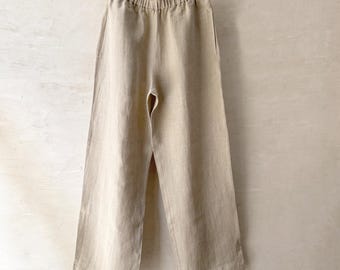 May include: A pair of beige linen pants with a wide leg and an elastic waistband.