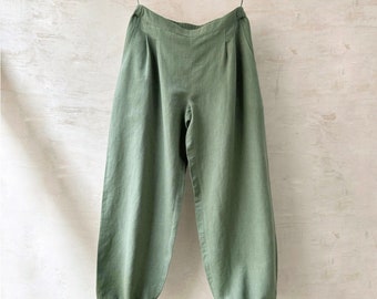 May include: Green linen pants with a wide leg and elastic waistband. The pants have a relaxed fit and are perfect for casual wear.