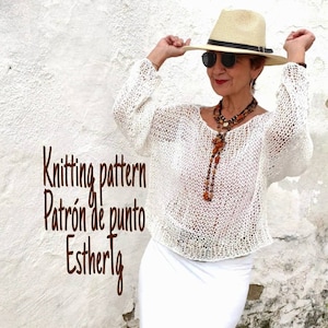Pu&ograve; includere: Top bianco all'uncinetto con una vestibilit&agrave; ampia e una scollatura ampia. Il top &egrave; indossato da una persona che indossa un cappello di paglia e occhiali da sole. Il testo "Knitting pattern Patr&oacute;n de punto Esthertlg" &egrave; visibile nell'immagine.
