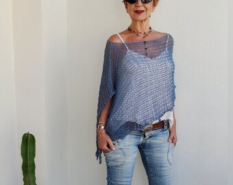 May include: A woman wearing a light blue crochet top with a white tank top underneath, blue jeans, and brown sandals. She is wearing a black beaded necklace and sunglasses.