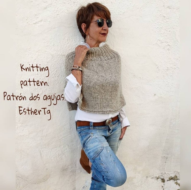 May include: A woman wearing a light brown knitted poncho with a high neck and a white shirt underneath. She is wearing blue jeans and brown shoes. The text "Knitting pattern. Patr&oacute;n dos agujas. EstherTg" is written in brown on a white background.