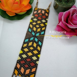 May include: A colorful beaded bracelet with a geometric pattern in shades of yellow, orange, blue, and black. The bracelet is made with small beads and has a unique design.  RJbyluciela © All Rights Reserved.