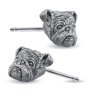 May include: A pair of silver bulldog head stud earrings. The earrings are made of metal and feature a detailed bulldog head design.
