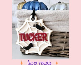 Può includere: Un ornamento di Halloween in legno tagliato al laser a forma di ragnatela con il nome "TUCKER" in lettere rosse. Tre ragni neri sono sulla ragnatela.