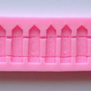 May include: Pink silicone mold with 16 individual molds for creating a picket fence design.
