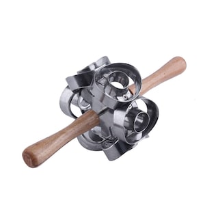 May include: A multi-donut cutter with six stainless steel donut-shaped cutters attached to a wooden handle. The wooden handles are light brown. The cutters are arranged in a circular pattern.