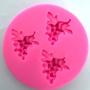 May include: Pink silicone mold with three grape cluster designs. Each cluster has a detailed design with individual grapes.