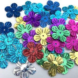 May include: Assortment of colorful flower-shaped sequins in various colors, including blue, green, purple, red, gold, and silver.