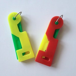 May include: Two plastic threader tools, one yellow and green, the other red and green. Both have a metal loop at the top.