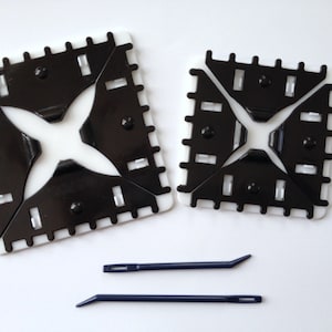 May include: Two white plastic knitting looms with black plastic needles, and two blue knitting needles.