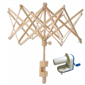 May include: A wooden yarn swift with a clamp base and a separate hand crank yarn winder. The swift is made of natural wood and has a starburst design. The winder is white with blue accents.
