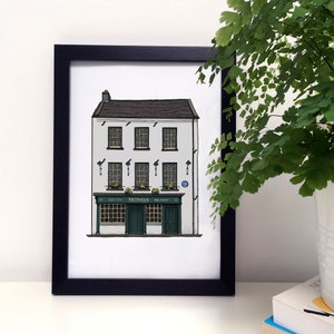 May include: Framed print of McHugh's Bar, Belfast. The illustration shows a three-storey building with a white facade, dark green doors and trim, and a black roof. The bar's name and establishment date are displayed on the facade.