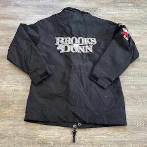 May include: Black jacket with a white "Brooks & Dunn" logo and a red and white embroidered design on the right sleeve.