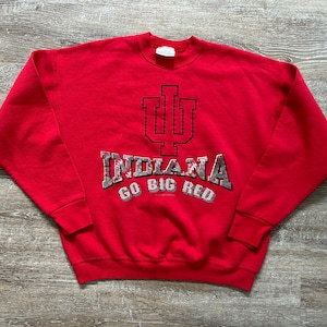 May include: Red sweatshirt with a large Indiana University logo and the words "Go Big Red" printed on the front.