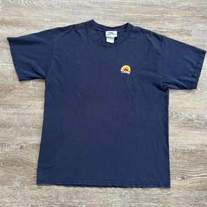 May include: Navy blue short-sleeve t-shirt with a small graphic of a sun and the word "TODAY" in white. The shirt is made of a soft material and has a crew neck.