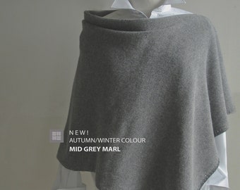 May include: A gray knitted poncho with a white shirt underneath. The text "NEW! AUTUMN/WINTER COLOUR MID GREY MARL" is printed on the poncho.