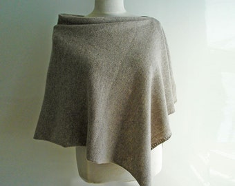 May include: A light brown knitted poncho with a draped neckline and a slightly asymmetrical hem.