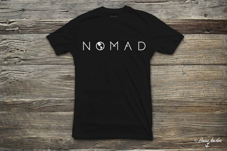 Puede incluir: Camiseta negra con un gr&aacute;fico blanco de la palabra "NOMAD" con un icono de globo terr&aacute;queo en la "O".