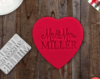 Pode incluir: Cortador de biscoitos em forma de coração vermelho com o texto "Mr & Mrs MILLER" em letras brancas.
