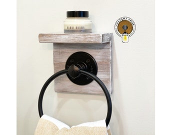 May include: Whitewashed wooden towel rack with a black metal ring and a small shelf. A jar of cream is on the shelf. The towel rack has a "TULIGHT SHOP" logo with a lightbulb graphic.