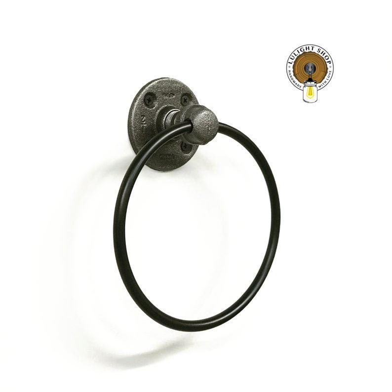 May include: Black metal towel ring with a round base and a pipe fitting design. The ring is attached to a white wall.