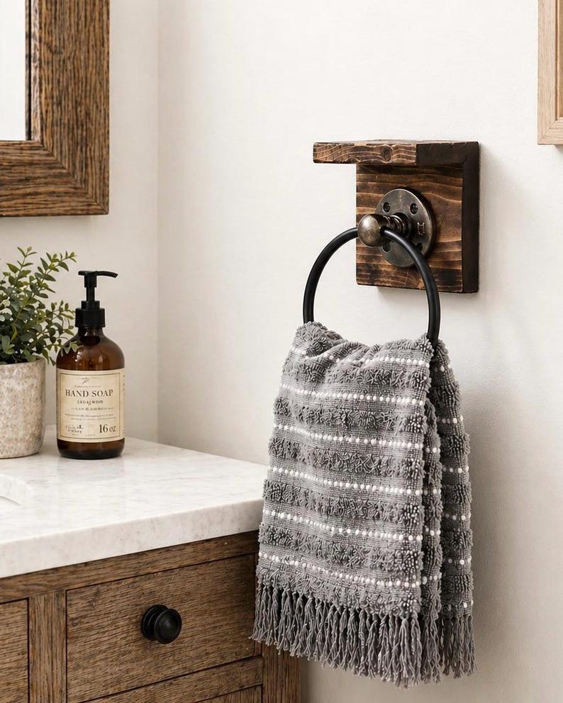 black pipe towel ring on rustic wood board with a small shelf for storage hanging a white towel next to the sink