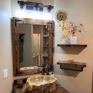 rustic mirror frame made with real wood hanging on the bathroom wall above a beautiful marble sink