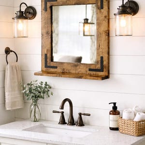 Handcrafted rustic wood framed mirror with a bottom shelf for storage, mounted on a bathroom vanity wall featuring a distressed finish and natural wood grain for a farmhouse-style charm.