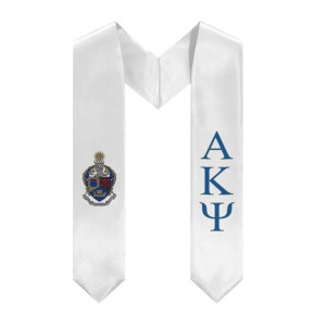 May include: White graduation stole with a blue and gold crest on the left side and the letters "AKΨ" in blue on the right side.