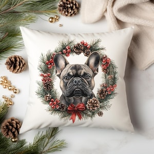 May include: A white pillow with a festive Christmas wreath design featuring a French bulldog. The wreath is decorated with pine branches, red berries, and pine cones.