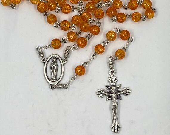19" orange crackle glass bead rosary with Madonna center and sunburst crucifix