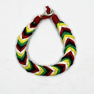 May include: A braided bracelet with red, white, green, and black threads. The bracelet has a silver clasp.