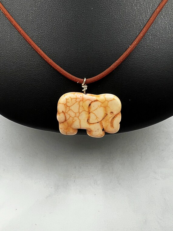 18" white carved howlite elephant on brown rubber cord