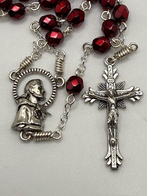 27.5" red glass faceted bead 7 decade crown rosary with St Francis center and feathered ends crucifix