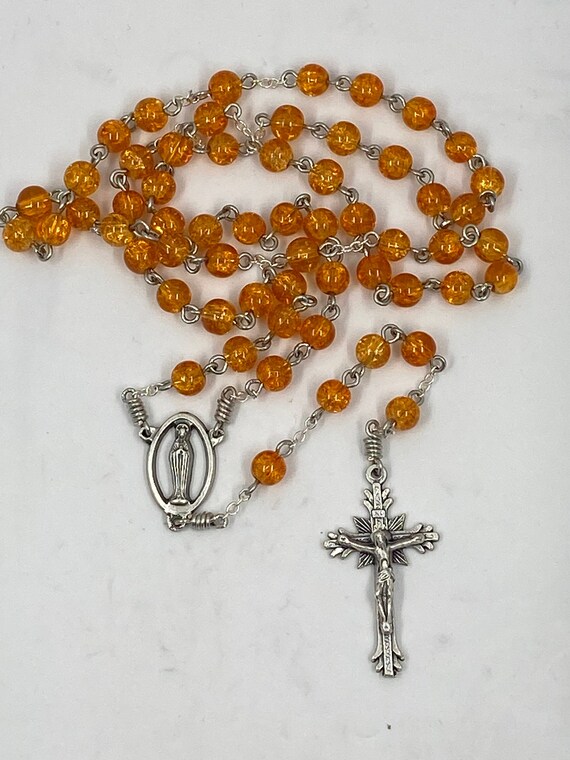 19" orange crackle glass bead rosary with Madonna center and sunburst crucifix