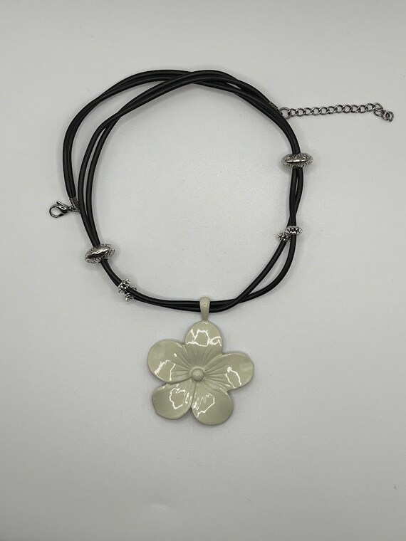19" metal flower pendant on black rubber cord with silver accents