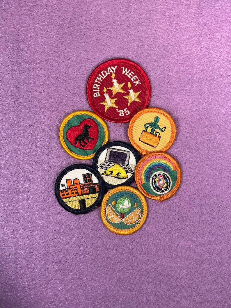 Puede incluir: Siete parches bordados con varios dise&ntilde;os, que incluyen un coraz&oacute;n con un lobo, un cactus, una computadora port&aacute;til, un arco&iacute;ris, un paisaje urbano, un &aacute;rbol y un parche de semana de cumplea&ntilde;os con tres estrellas y el n&uacute;mero '85'.