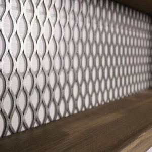 May include: A close-up of a wooden shelf with a metal mesh backing. The mesh is a diamond pattern with a silver finish.