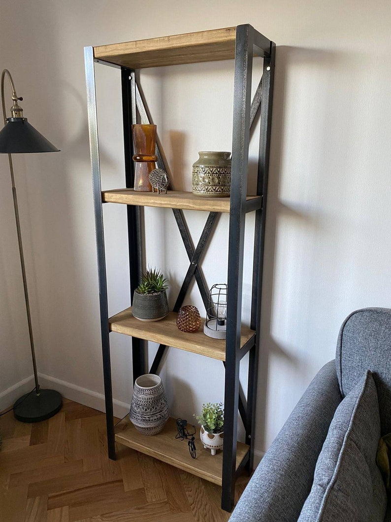 May include: A black metal shelf unit with four wooden shelves. The shelves are decorated with various items, including a vase, a lamp, and a potted plant.