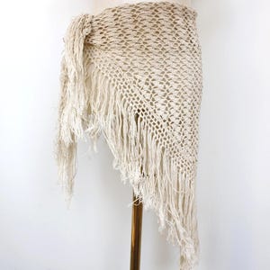 Puede incluir: Una taza de cerámica blanca con un asa negra y el texto "But First, Coffee" en negrita negra. La taza se encuentra sobre un fondo borroso, sugiriendo un ambiente acogedor.